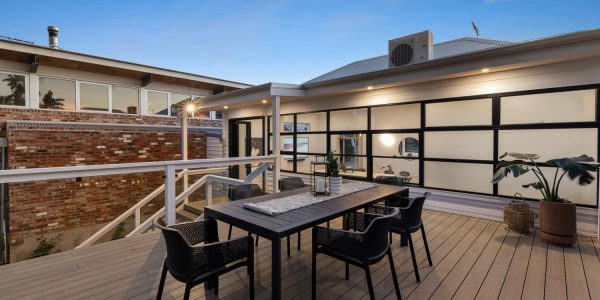 A modern deck with a black table and chairs